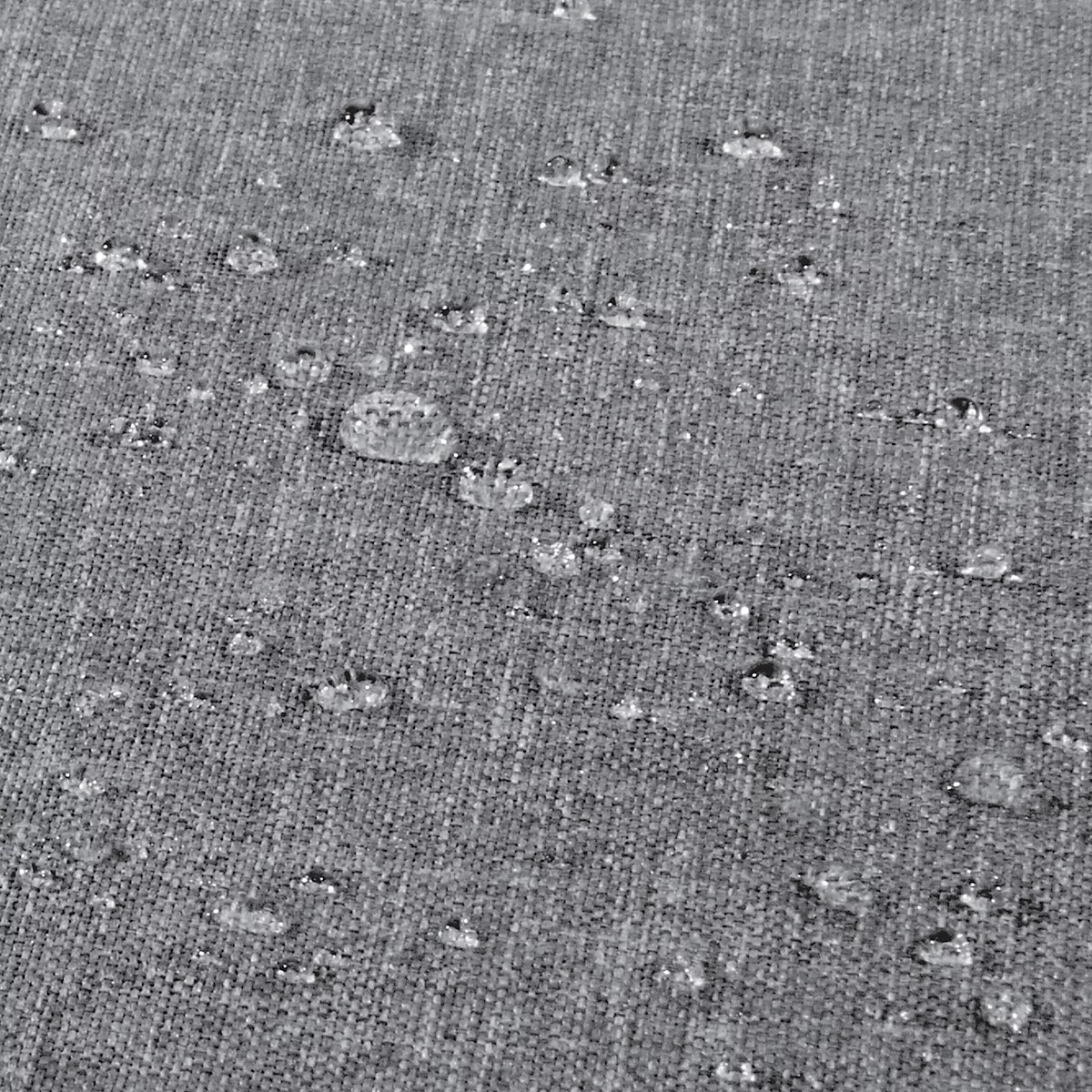 Gros plan sur un tissu gris avec des gouttelettes d'eau à la surface.