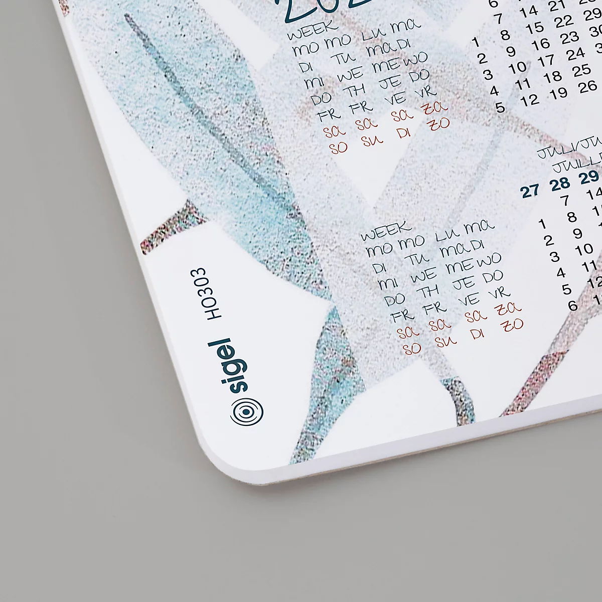 Gros plan sur un calendrier avec aperçu mensuel et hebdomadaire, décoré de motifs floraux abstraits en turquoise et marron.