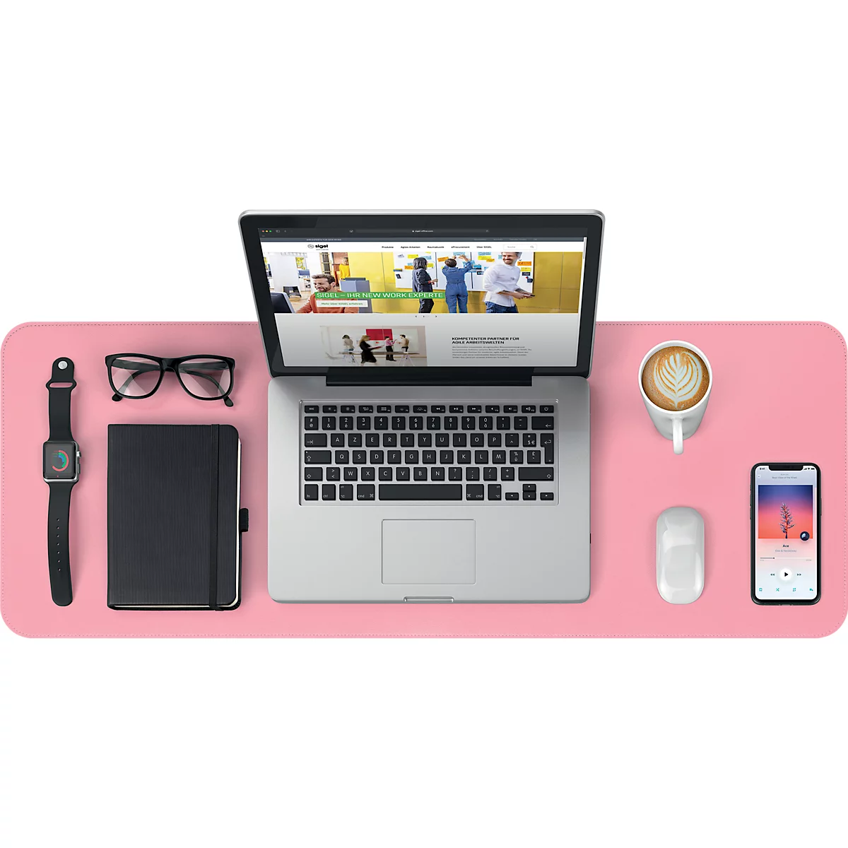 Vue de dessus d'un bureau : ordinateur portable, lunettes, carnet, tasse de café, smartphone et souris sur une surface rose.