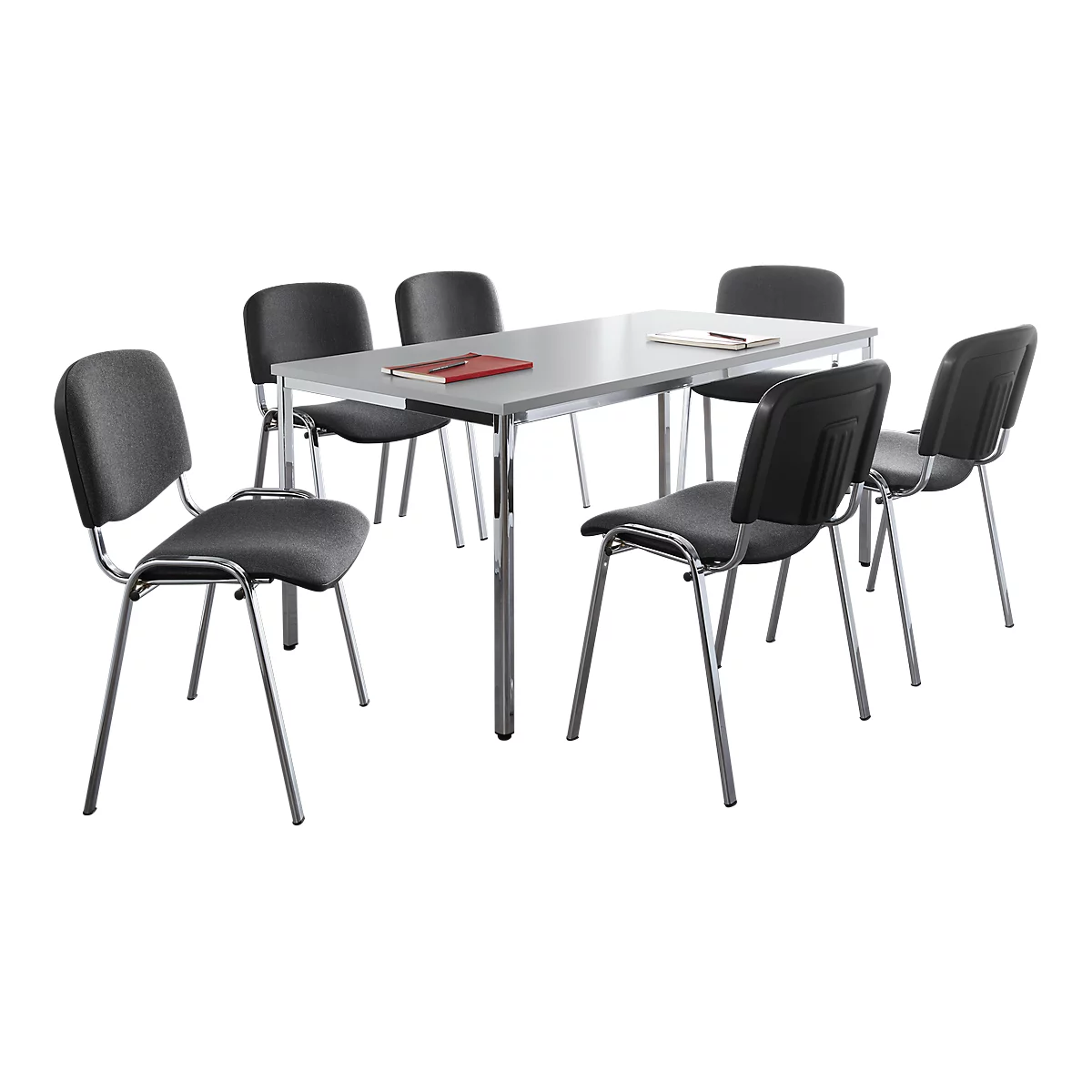 Grauer Tisch mit sechs Stühlen. Auf dem Tisch liegen ein rotes Notizbuch und Stifte.