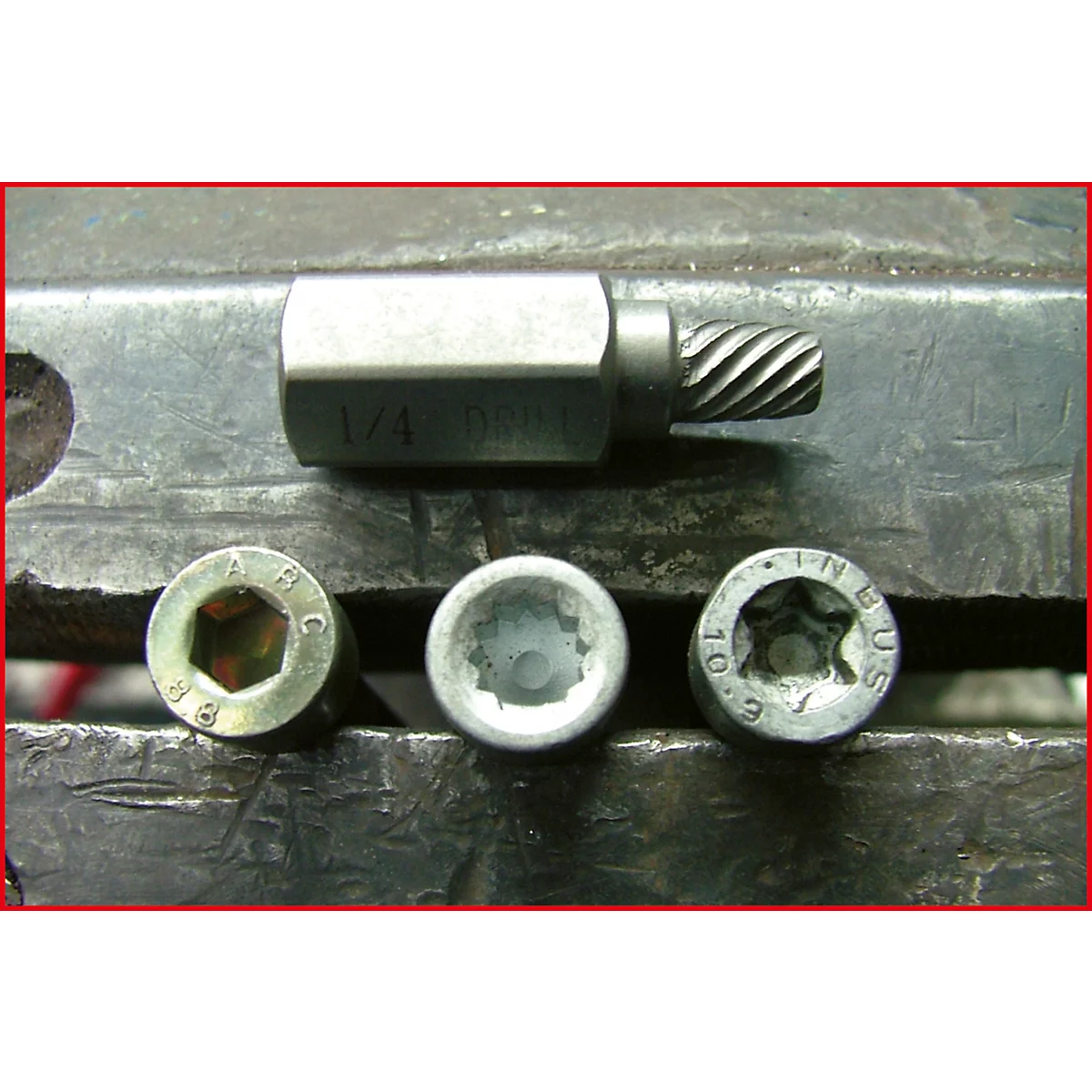 Werkzeug zum Entfernen von Schrauben mit einem Schraubenkopf und drei Schraubenköpfen. Metallisch, Details sichtbar.