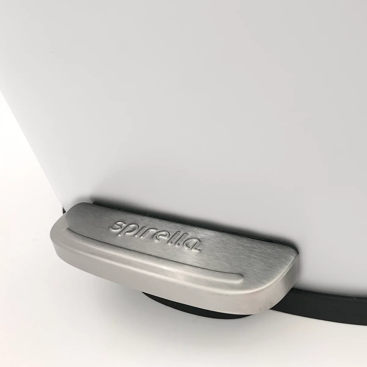 Gros plan sur la pédale d'une poubelle blanche, en acier inoxydable avec l'inscription 'spirella'.