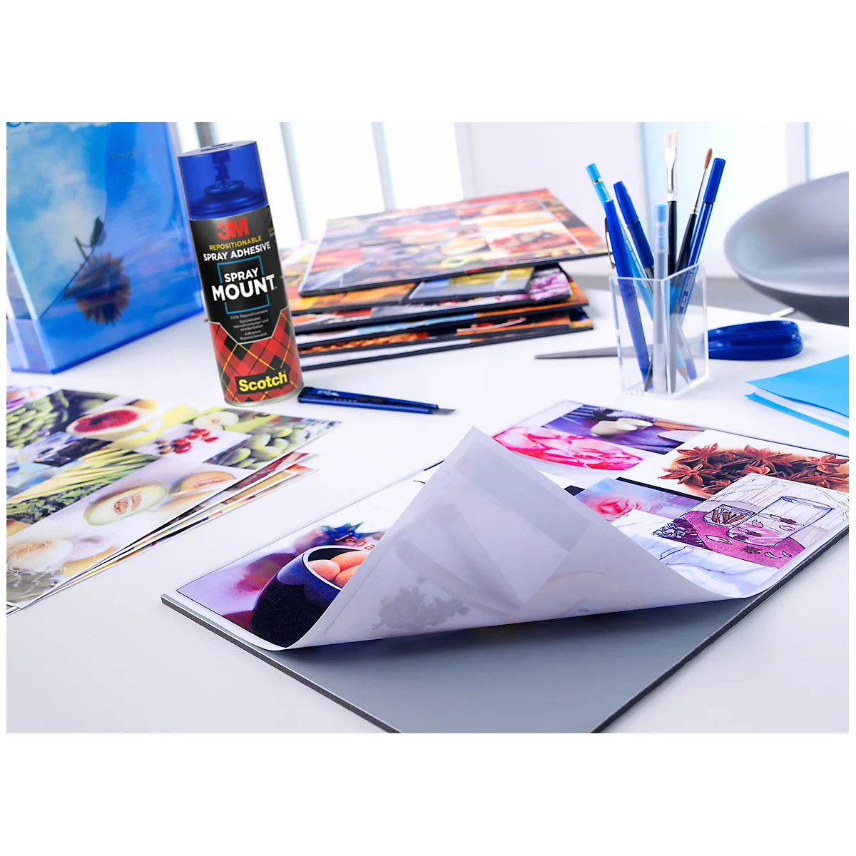 Blue spray adhesive and photos on a table.