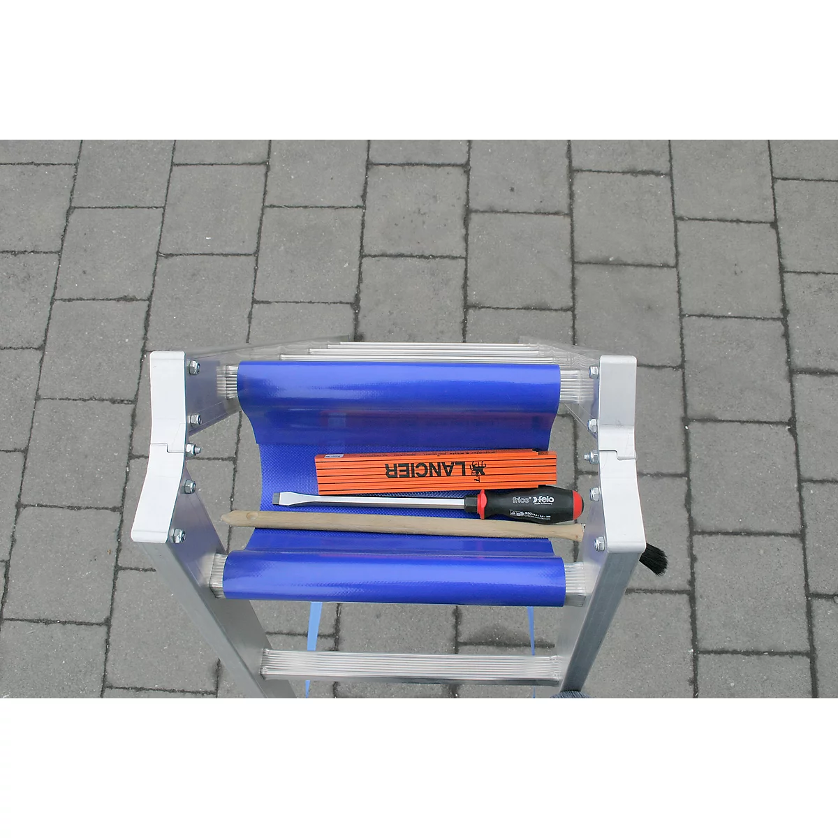 Blaue Trittleiter mit Werkzeug: Zollstock, Schraubendreher, Holzstiel.