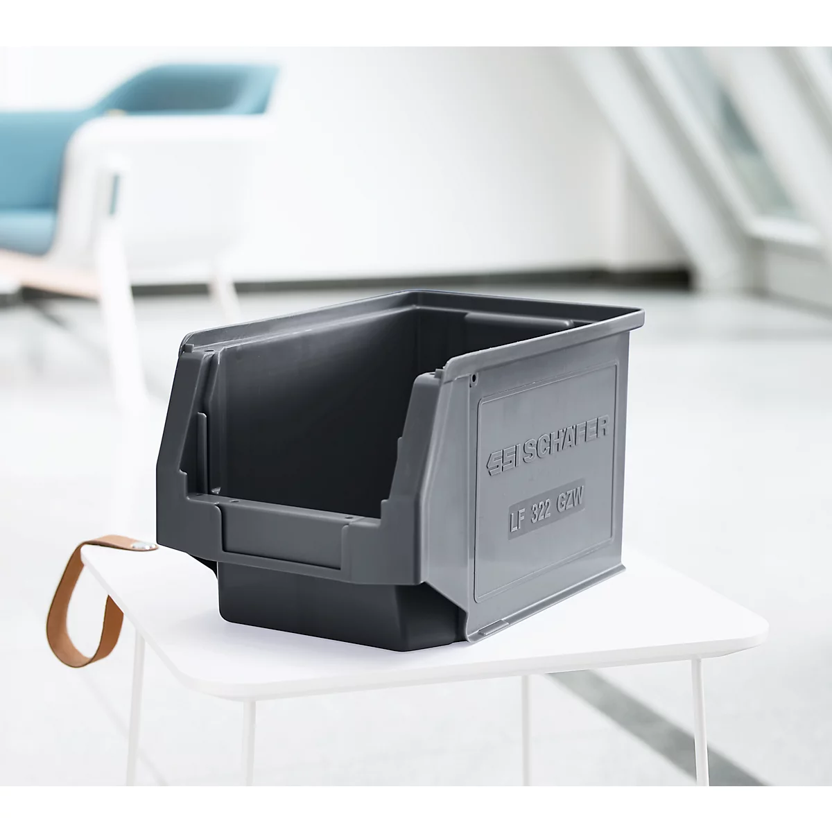 Graue, offene Kunststoffbox steht auf einem weißen Tisch. Auf der Seite ist der Schriftzug "GEISSINGER" zu sehen.