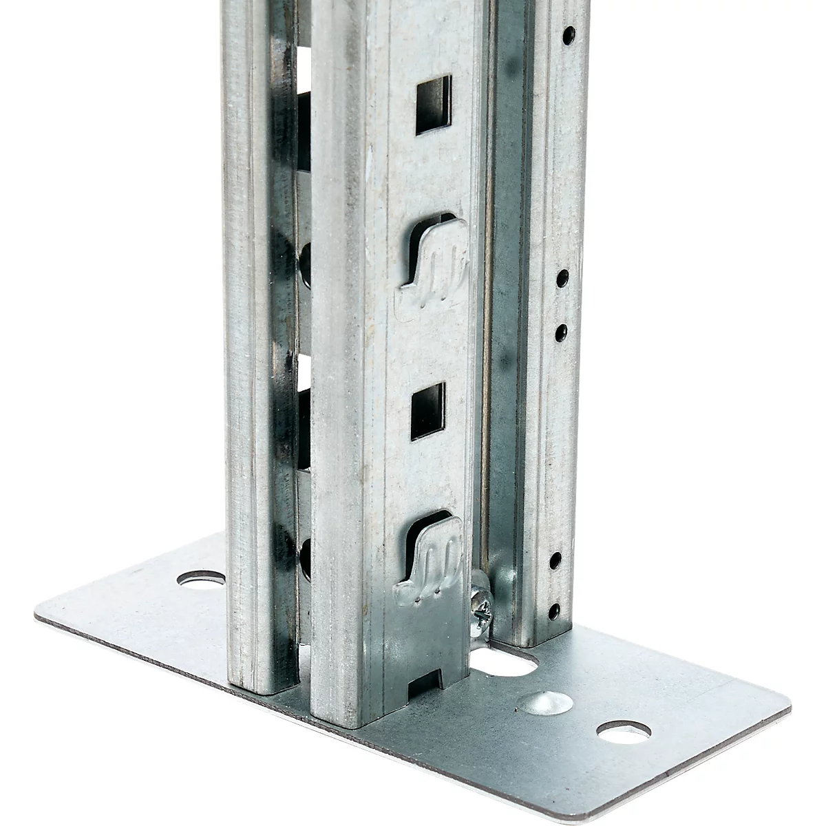 Close-up of a metallic shelf support base with square holes and recesses screwed into a metal plate.