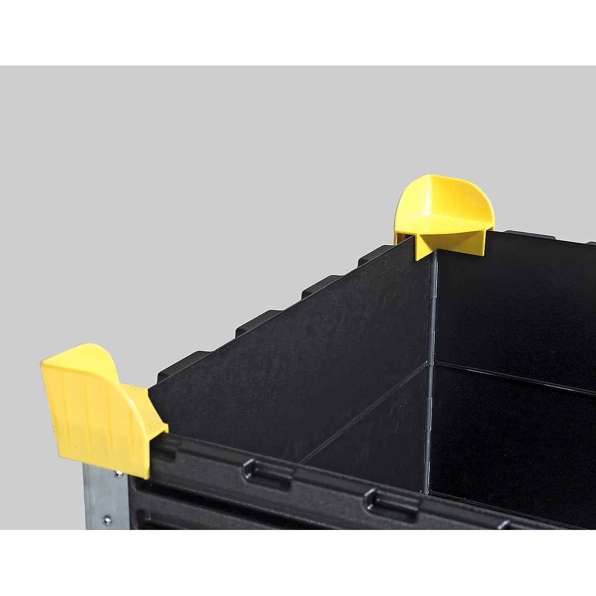 Detailed close-up of a black box with yellow corner elements. The ribbed edges and shape are clearly visible.