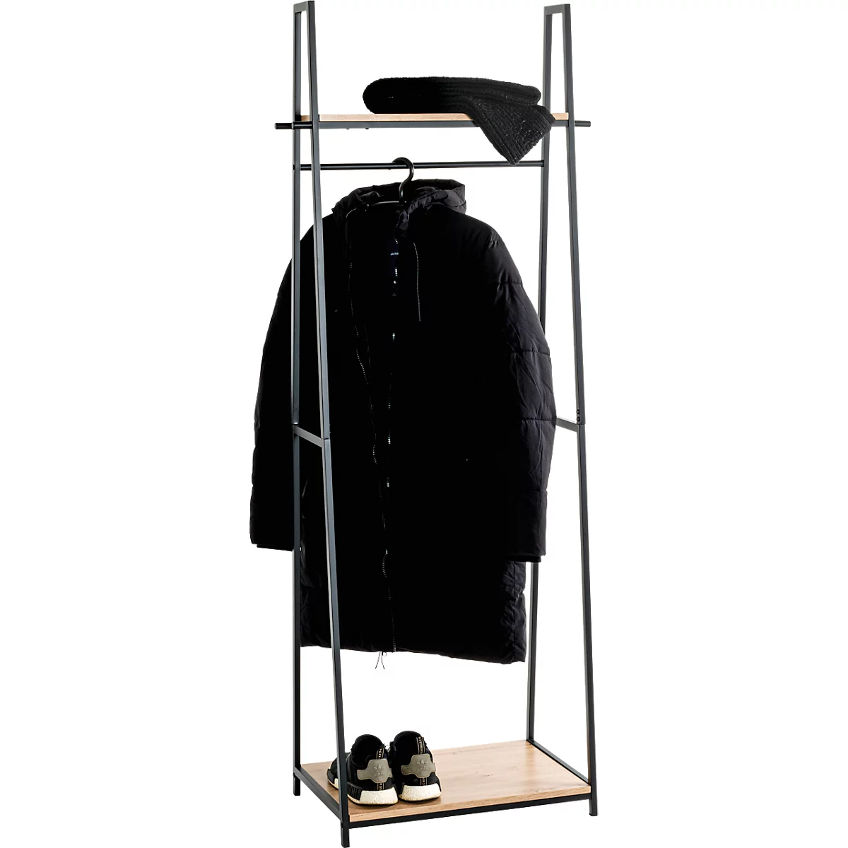 Schwarze Jacke hängt an einem Kleiderständer, zusammen mit einer Mütze und Schuhen.