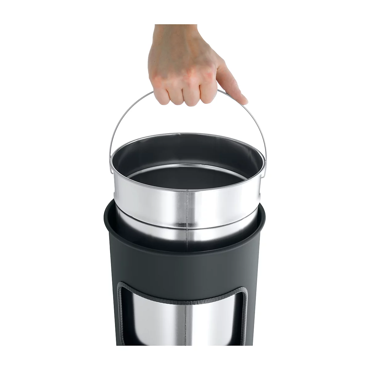 Hand holding a metal container with handle. The container is in a black plastic housing.