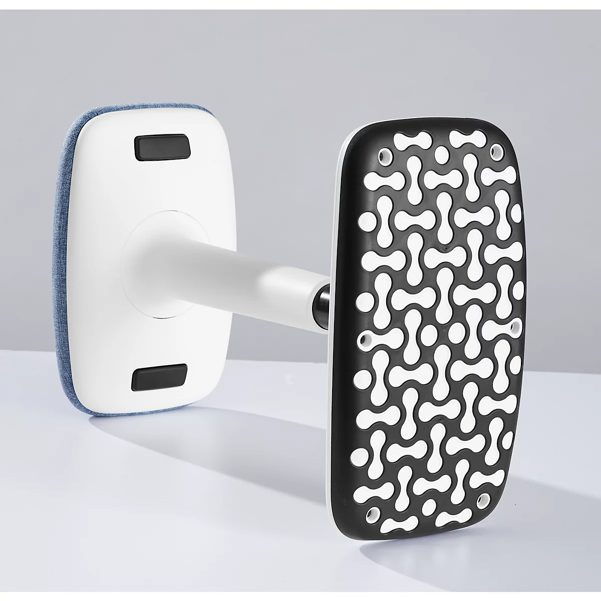 A white device with two rectangular ends. One end has a blue fabric, the other a black surface with a white pattern.