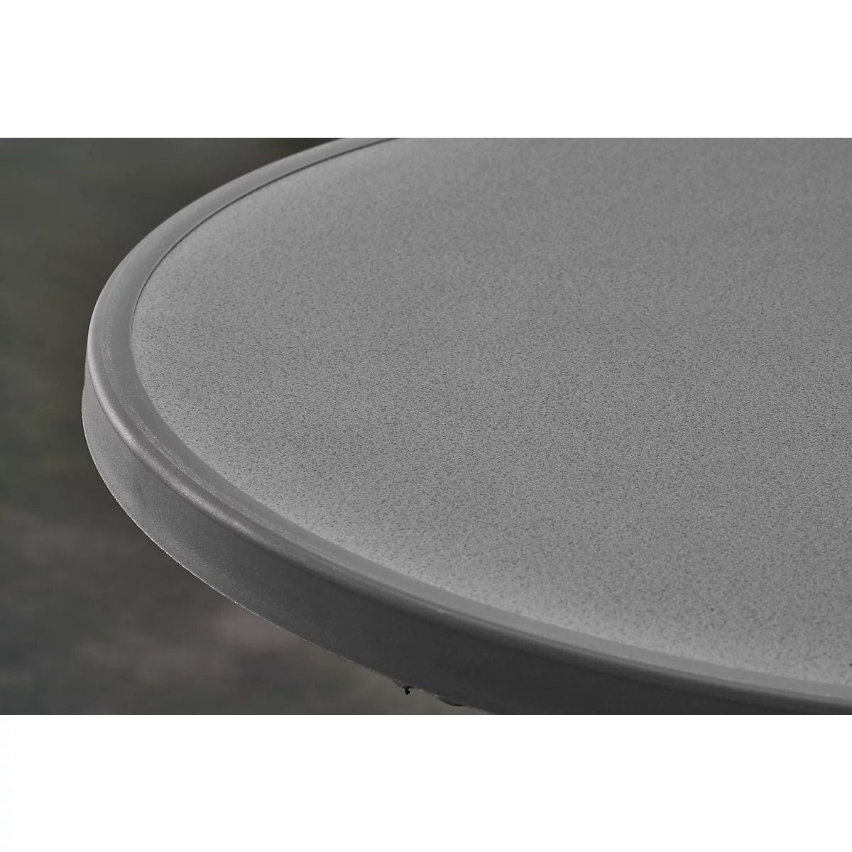 Close-up of part of a gray round table with visible grain and dark edge.