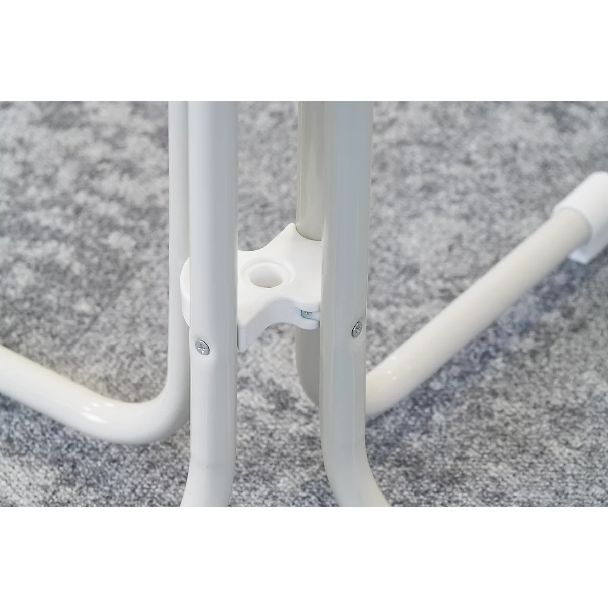 Close-up of white, three-legged frame with connecting pieces.
