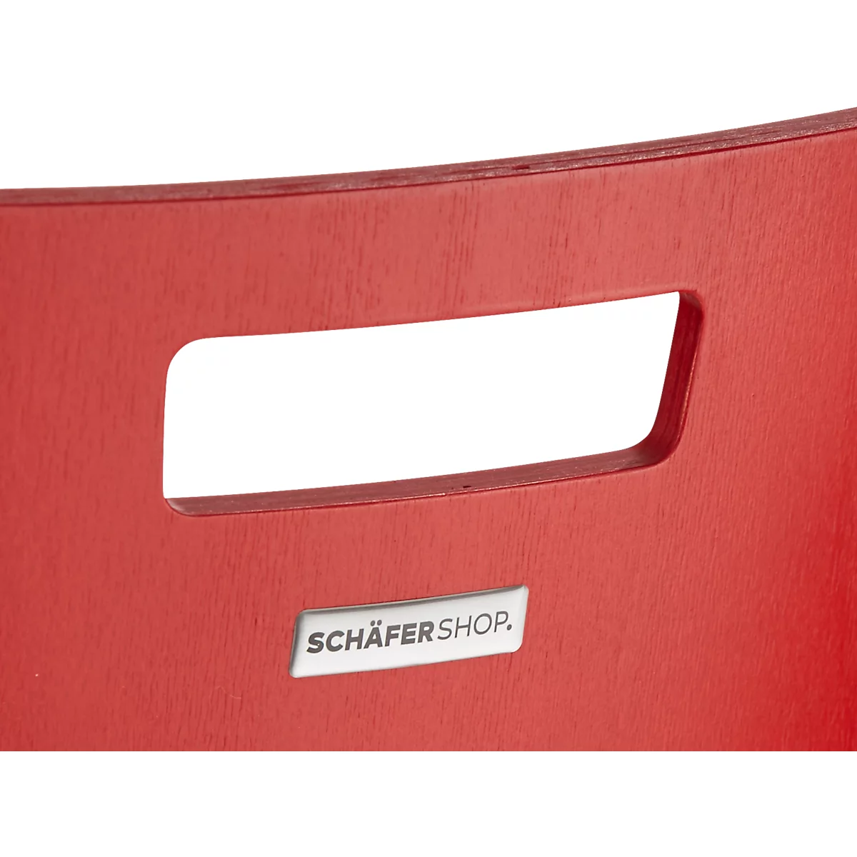 Close-up van een rode stoel. Een rechthoekige handgreepuitsparing met afgeronde hoeken en een "SCHÄFERSHOP"-bord.