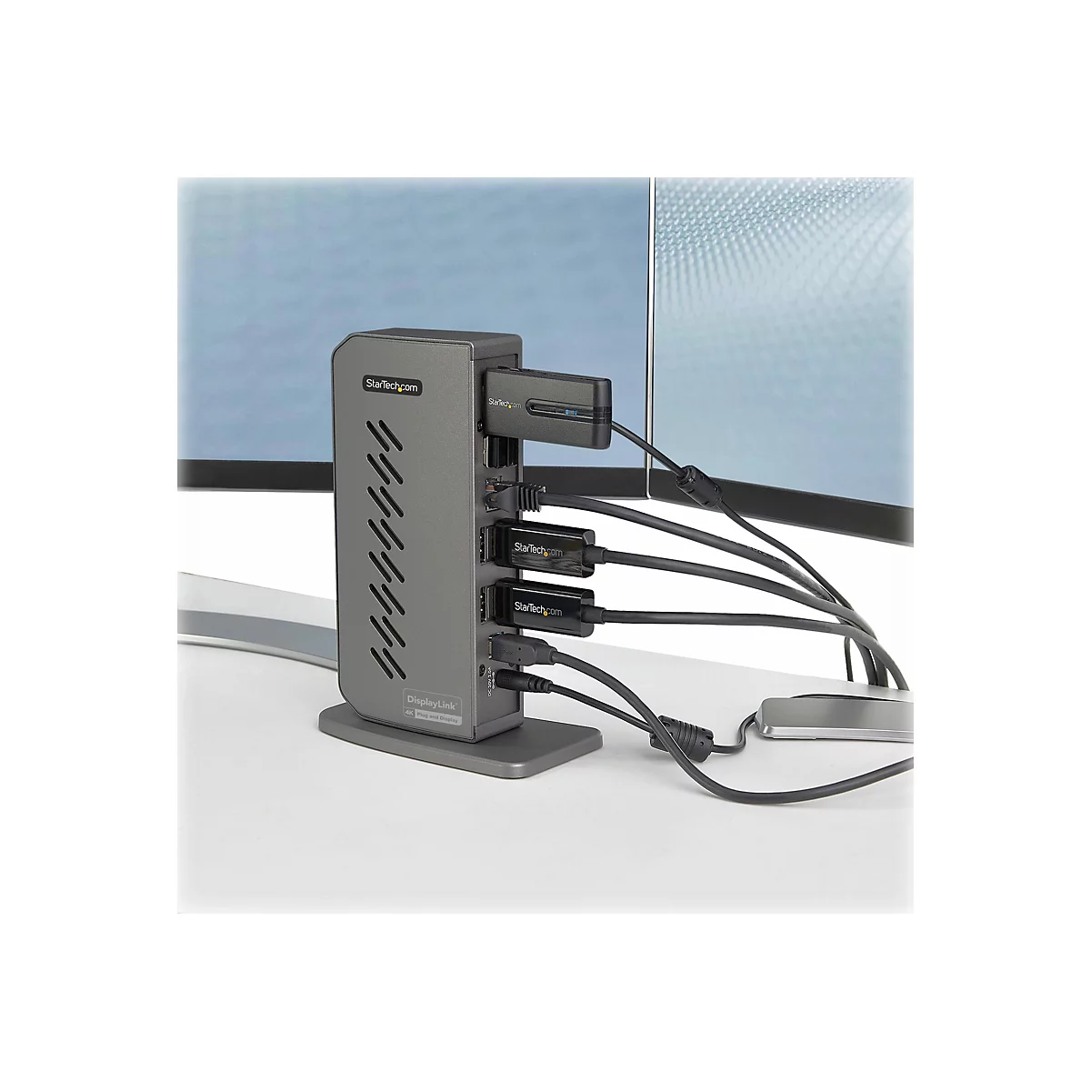 Adaptateur d'accueil gris avec cÃ¢bles et appareils connectÃ©s, placÃ© sur une surface blanche.