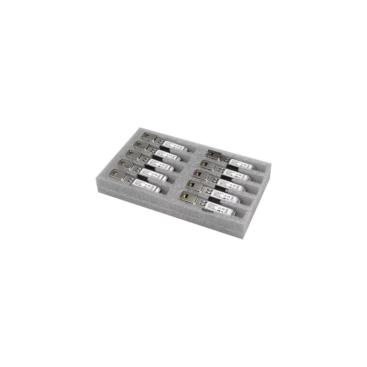 Un insert en mousse grise avec des renfoncements rectangulaires contenant des rangées de petits composants électroniques rectangulaires argentés et blancs.