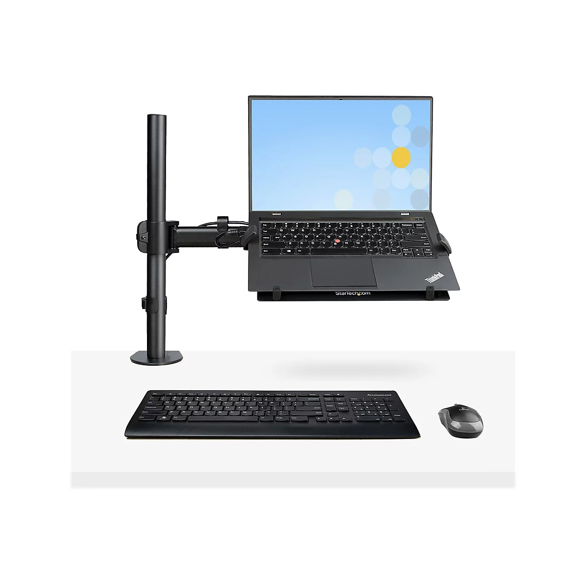 Ein Laptop, der auf einem Monitorhalter mit Tastatur und Maus steht.