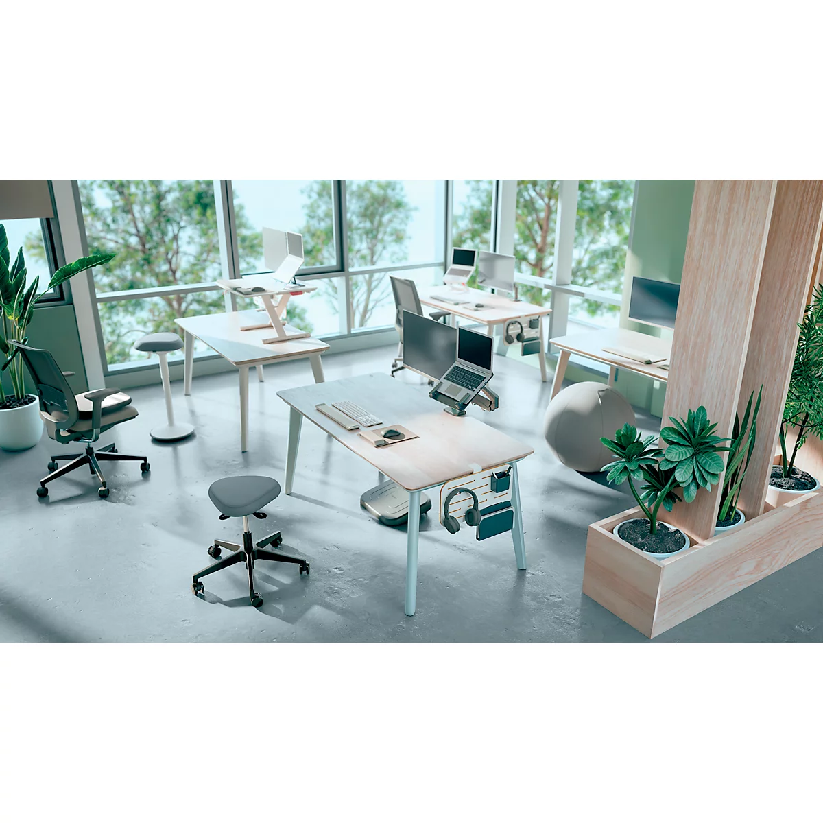 Büro-Szene mit Schreibtischen, Stühlen, Pflanzen und Fenstern mit Blick auf Bäume. Ein Laptop steht auf einem Tisch.