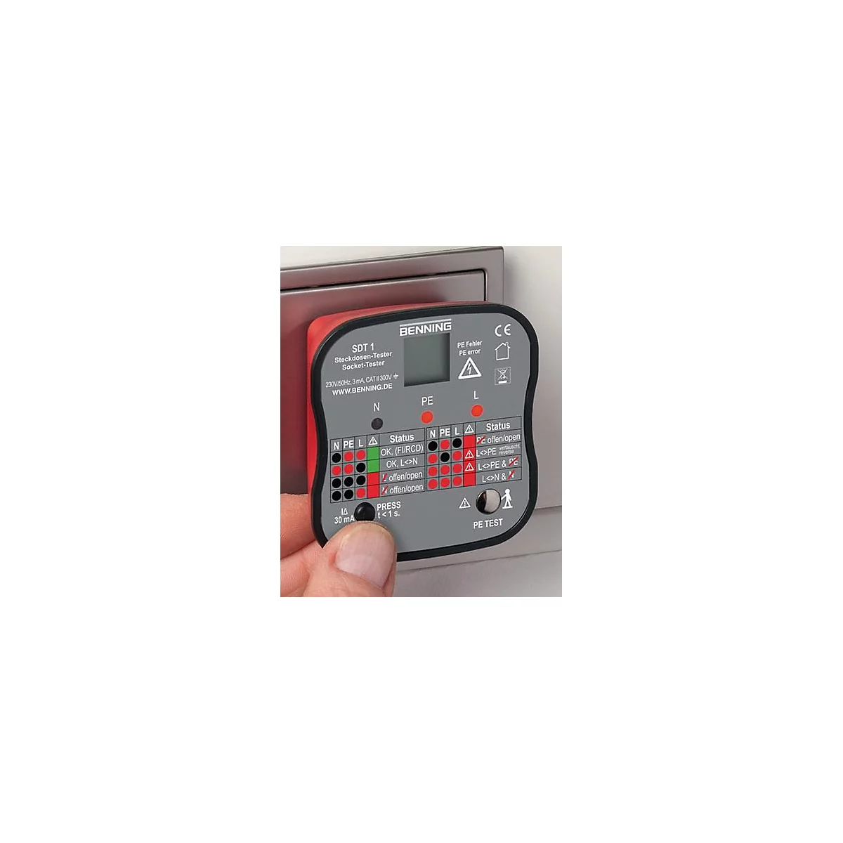 Een rode stopcontacttester met grijze bedieningselementen wordt door een hand voor een stopcontact gehouden. De tester toont verschillende resultaten.