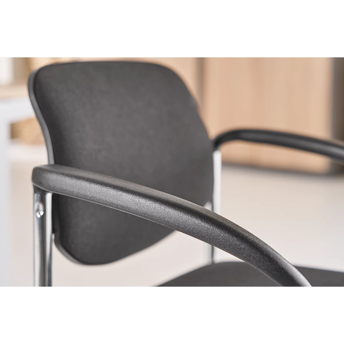 Close-up of a black office chair with armrest and backrest.