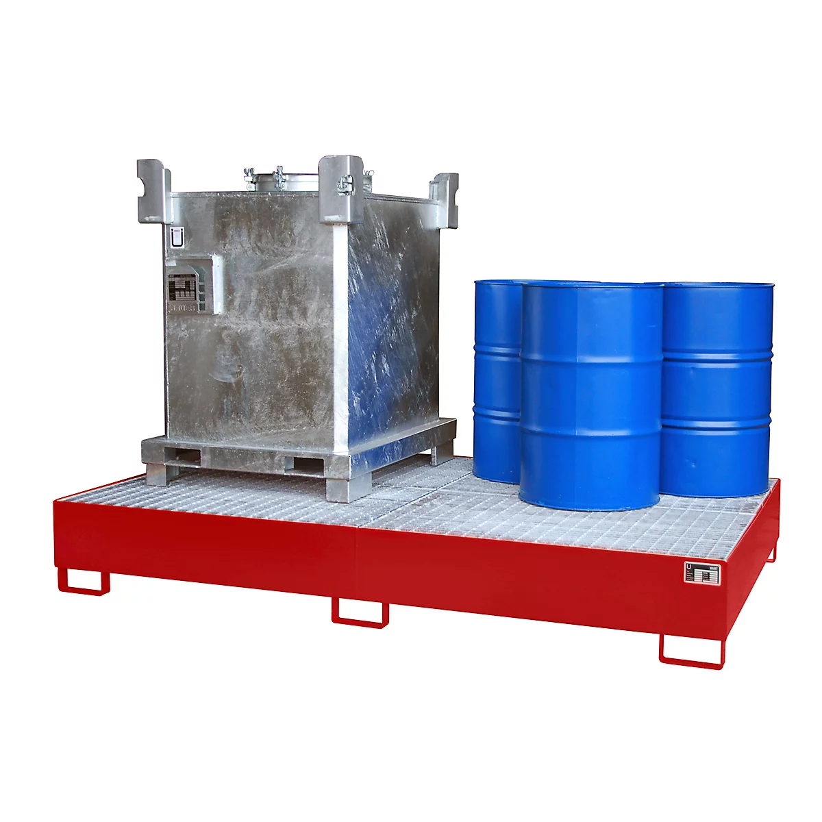 A metallic container and blue barrels stand on a red platform with grating.