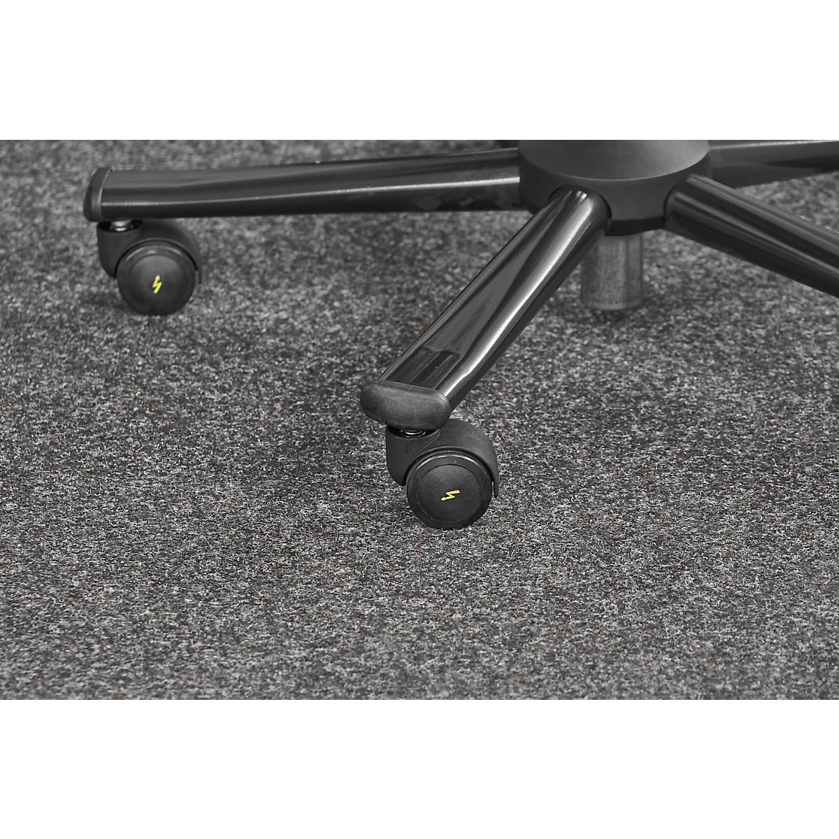 Detail shot of the castors of an office chair. Yellow lightning bolts are depicted on the black plastic.