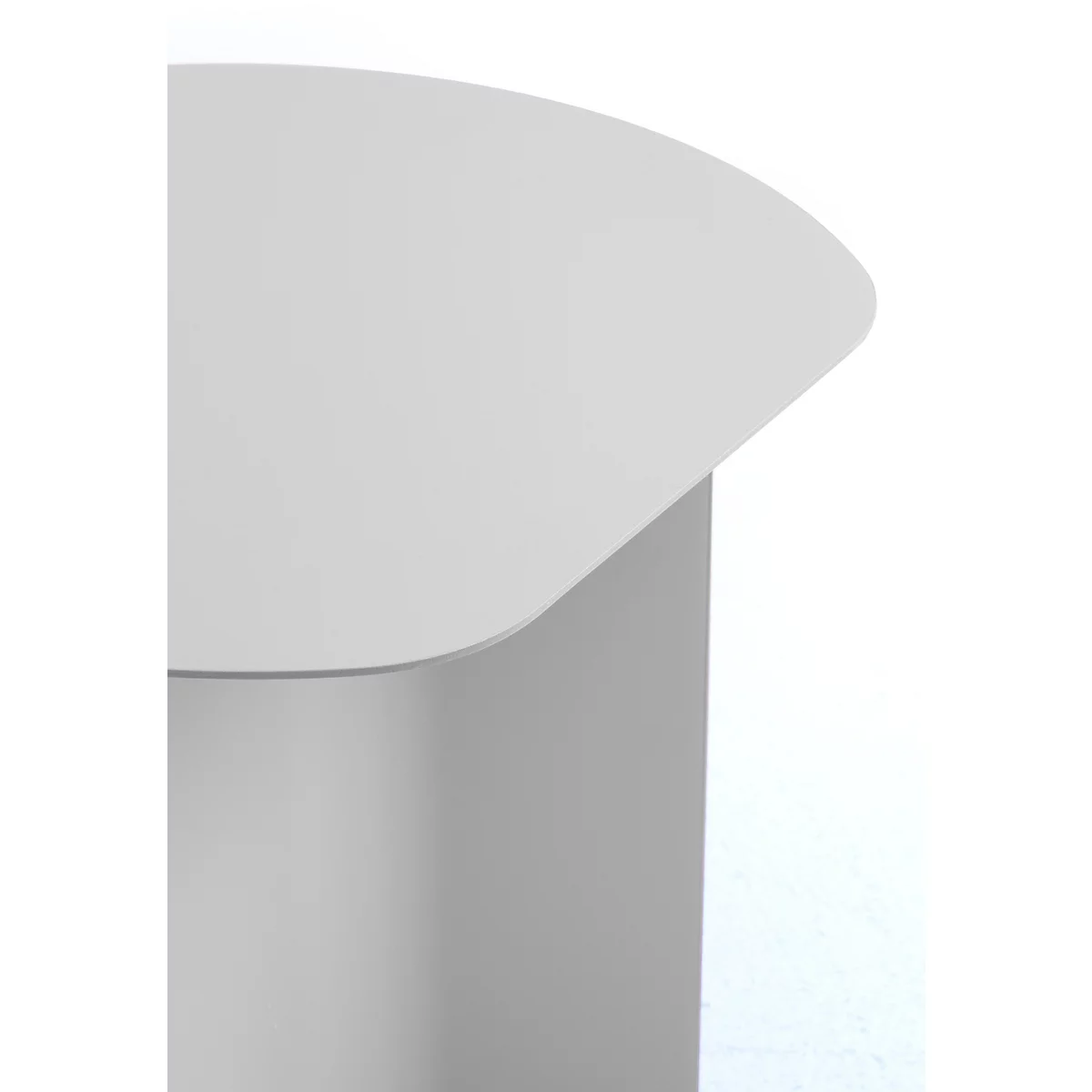 Gros plan sur le coin arrondi d'un plateau de table gris clair avec un pied lisse sur fond blanc.