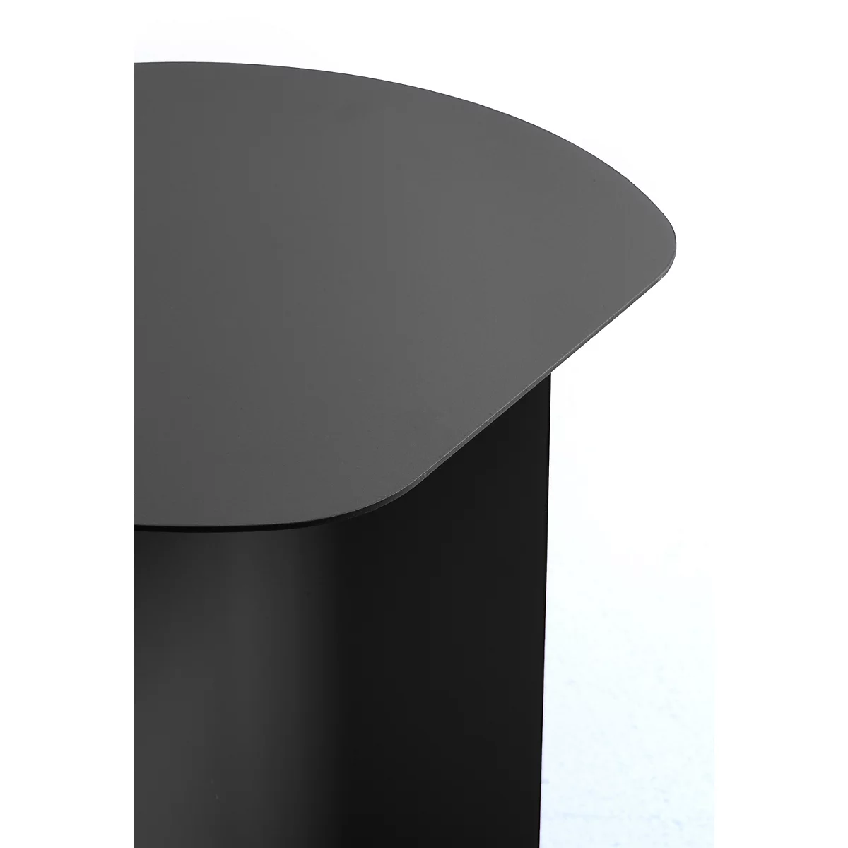 Gros plan sur un plateau de table noir incurvé en métal, reposant sur un pied cylindrique simple.
