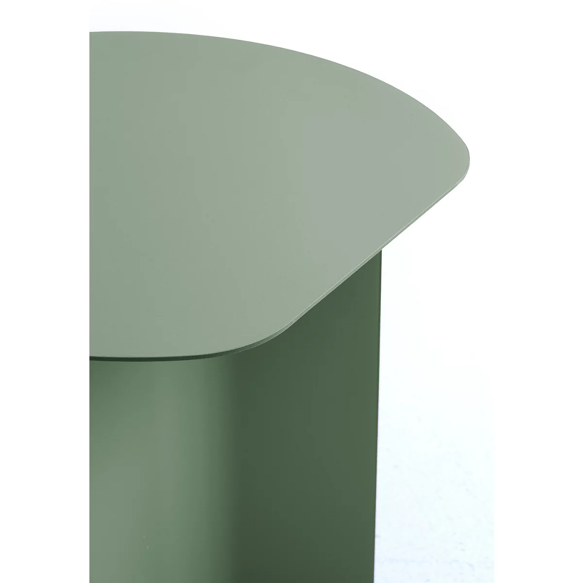Gros plan sur le plateau arrondi d'une table d'appoint en métal vert sauge sur fond blanc.