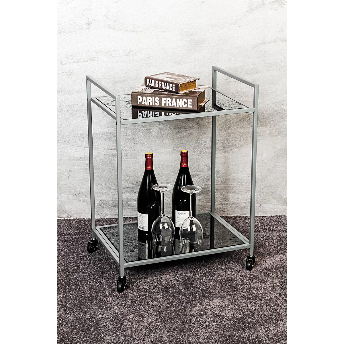 Chariot de service avec deux bouteilles de vin, des verres et des livres. Il est écrit "PARIS FRANCE".