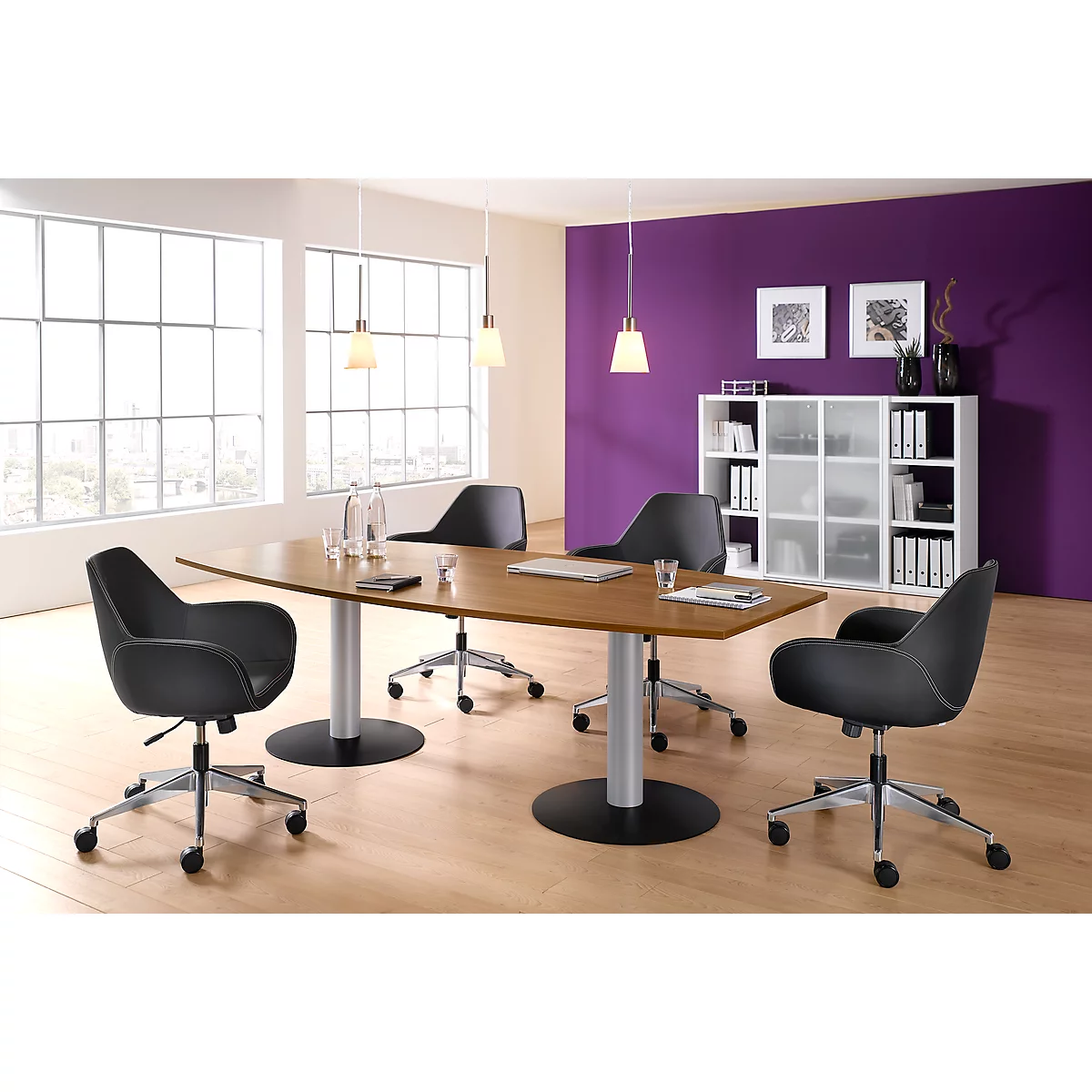 Table de conférence avec chaises noires, dans un bureau moderne. Le fond est partiellement violet.