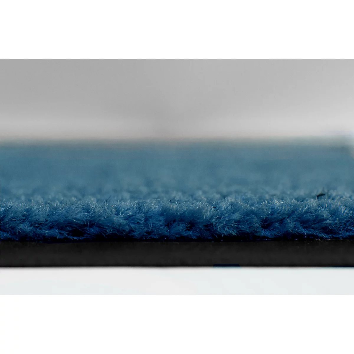 Gros plan sur une surface de tapis bleu foncé texturée.