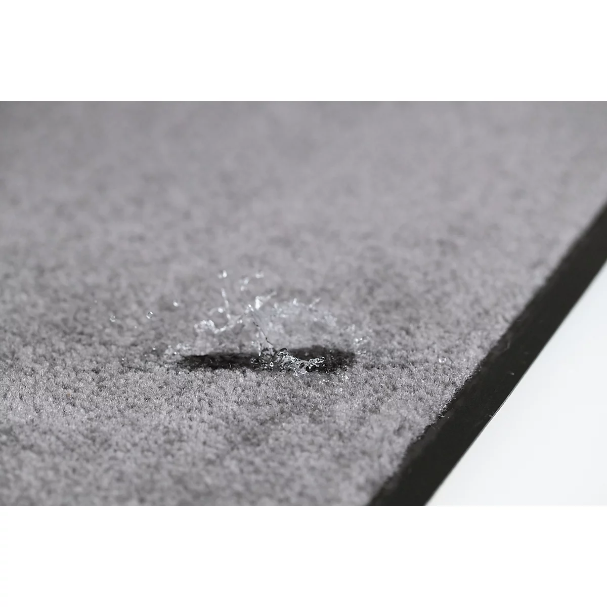 Gros plan sur une surface textile grise avec une petite fente ou coupure sombre.