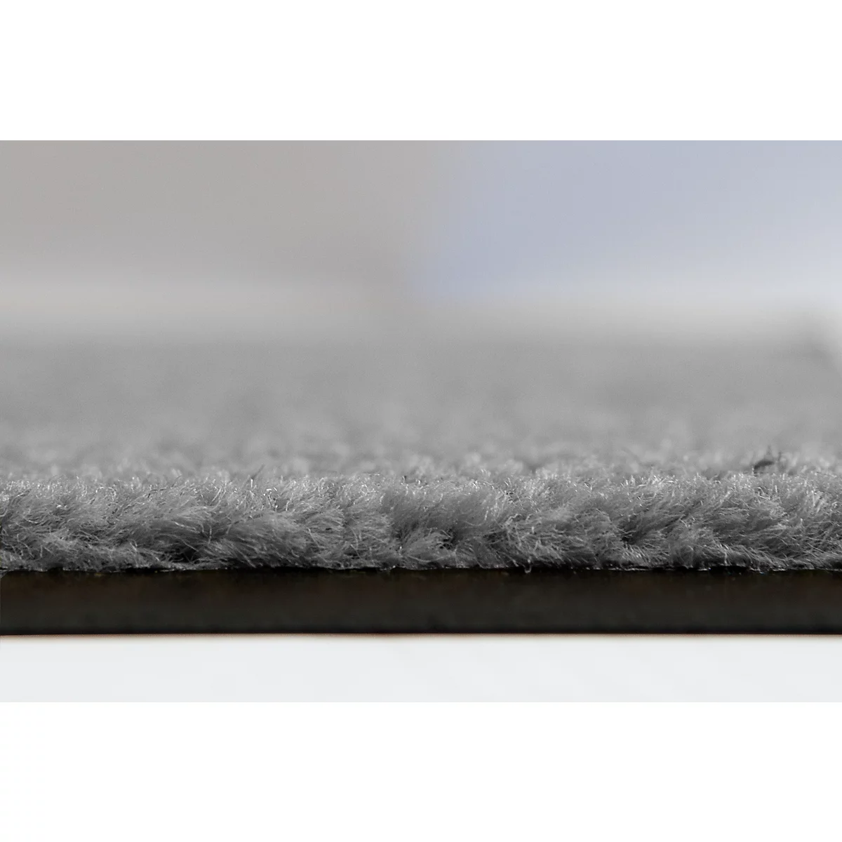 Gros plan d'une surface textile grise et duveteuse avec une texture douce et irrégulière.