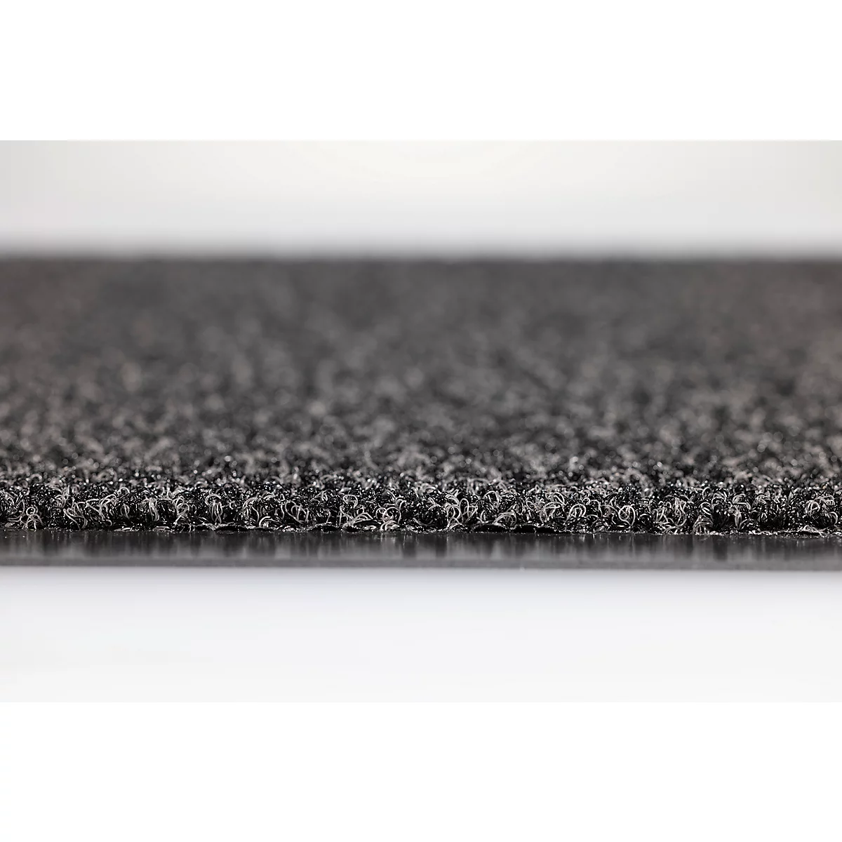 Gros plan sur un paillasson gris texturé à la surface dense et fibreuse.