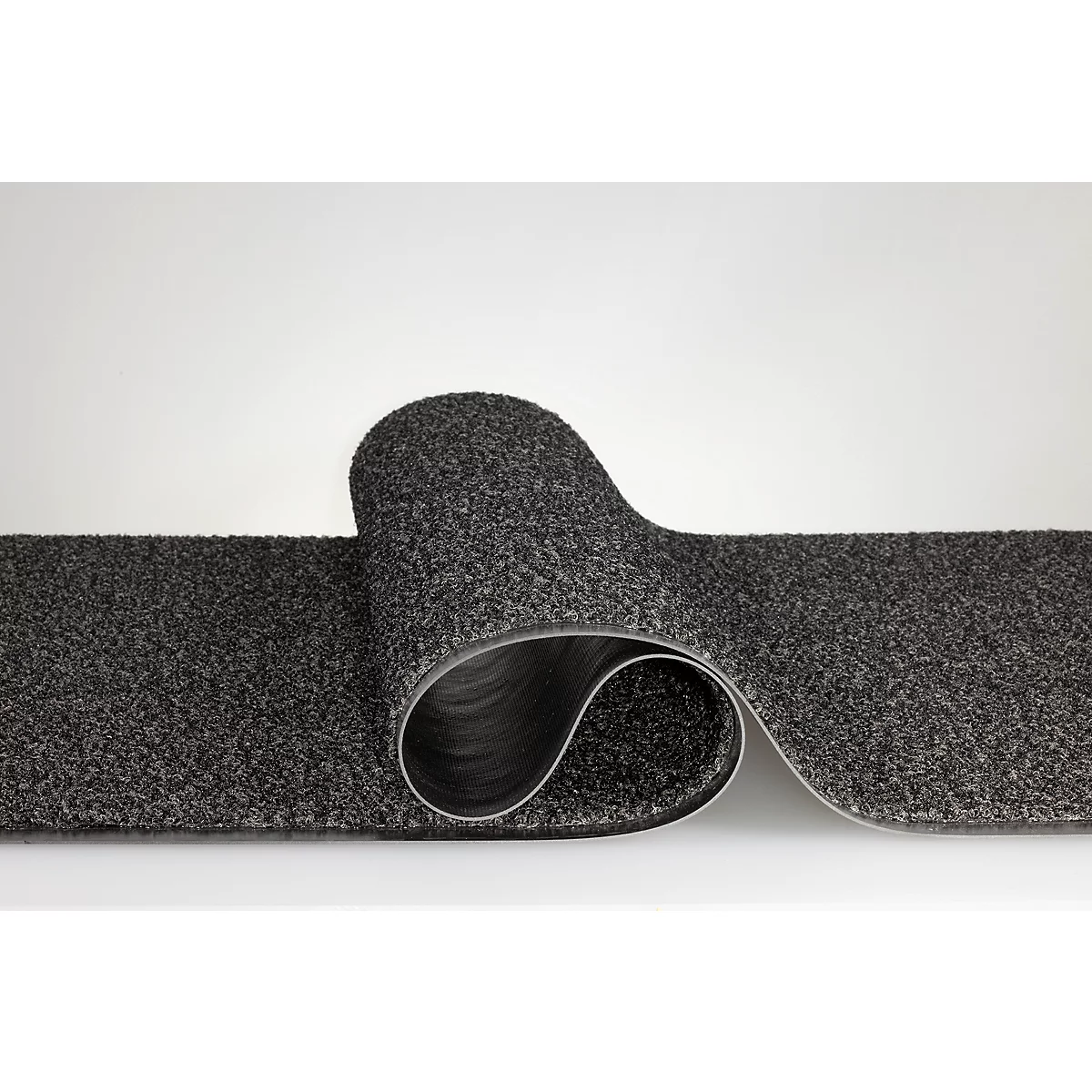 Une bande de tapis grise et texturée se courbe en forme de S sur un fond neutre.