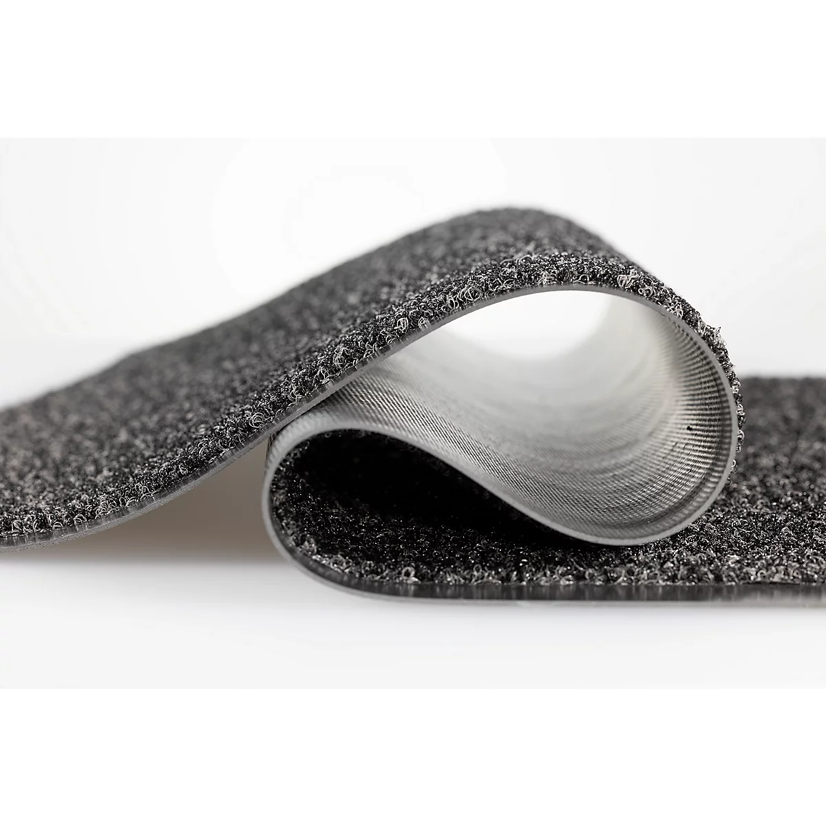 Un revêtement gris à gros grains enroulé, révélant son envers lisse.
