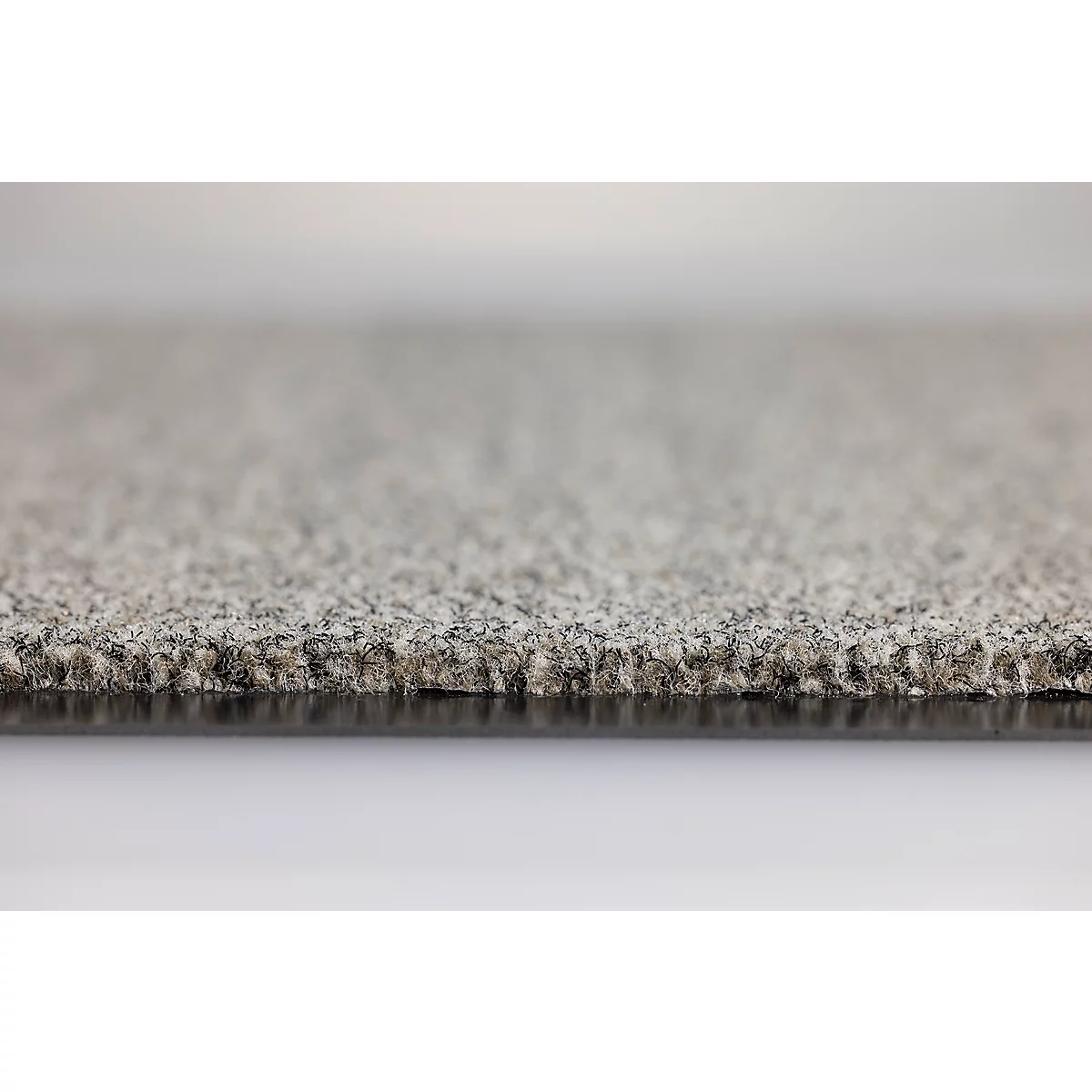 Gros plan sur une dalle de moquette grise à la texture mouchetée et au dossier noir.