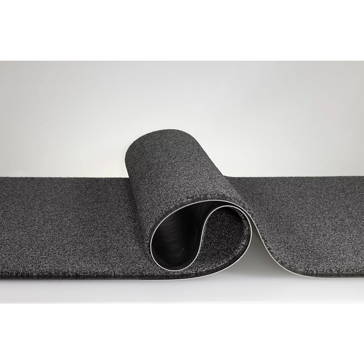 Un chemin de tapis gris foncé enroulé en forme de S, devant un fond clair.