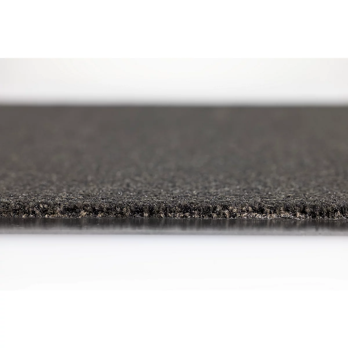 Gros plan sur un tapis en caoutchouc sombre et granuleux avec une texture de surface rugueuse sur fond blanc.