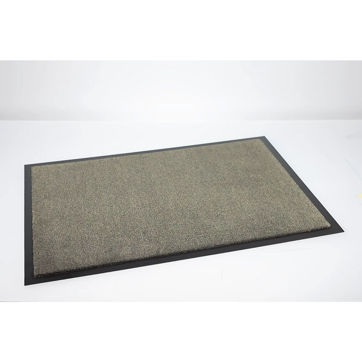 Paillasson gris rectangulaire avec bordure en caoutchouc noir sur fond blanc.