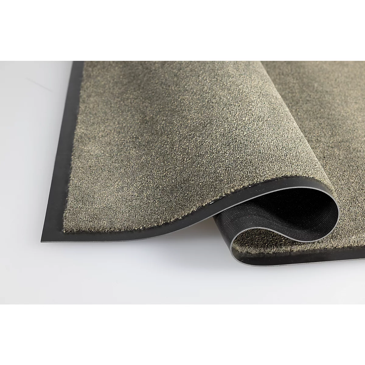 Gros plan sur un tapis d'entrée gris avec un coin replié, révélant le dessous en caoutchouc noir.
