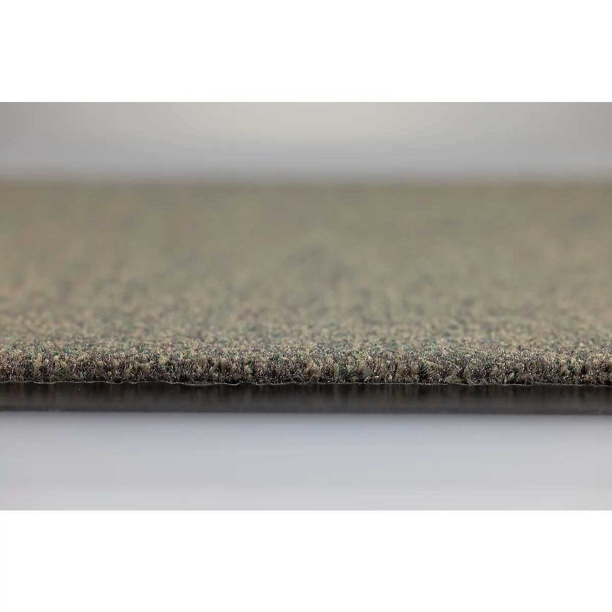 Gros plan sur la texture d'un revêtement de sol ou d'un tapis gris-brun avec une sous-couche visible.