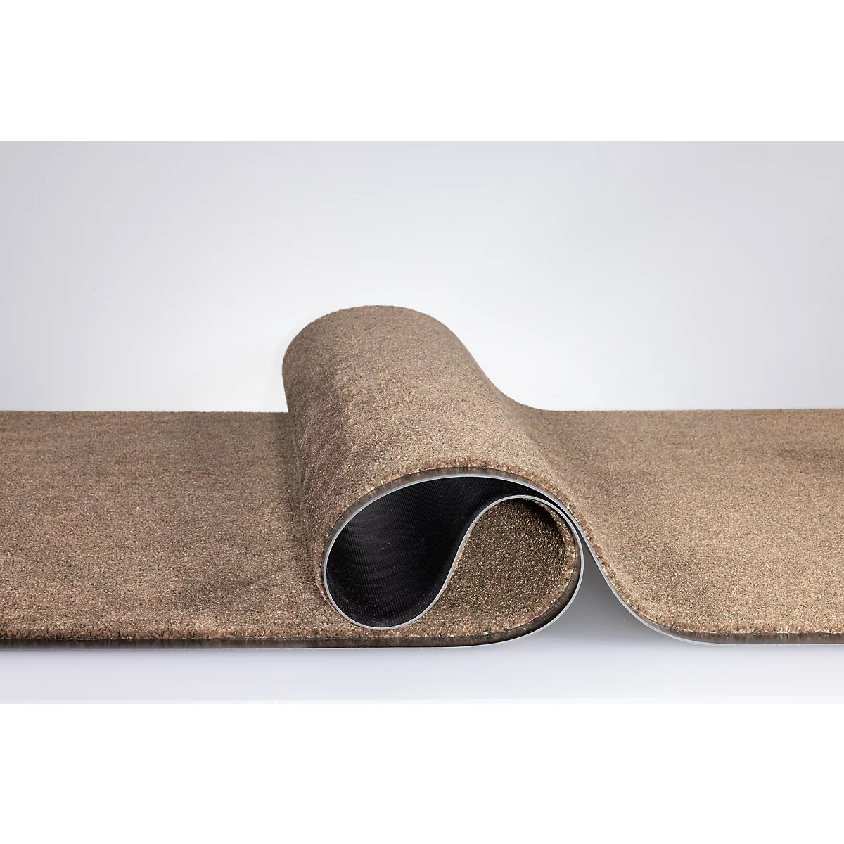 Un revêtement de sol en moquette marron enroulé, laissant apparaître le dos noir et résistant.