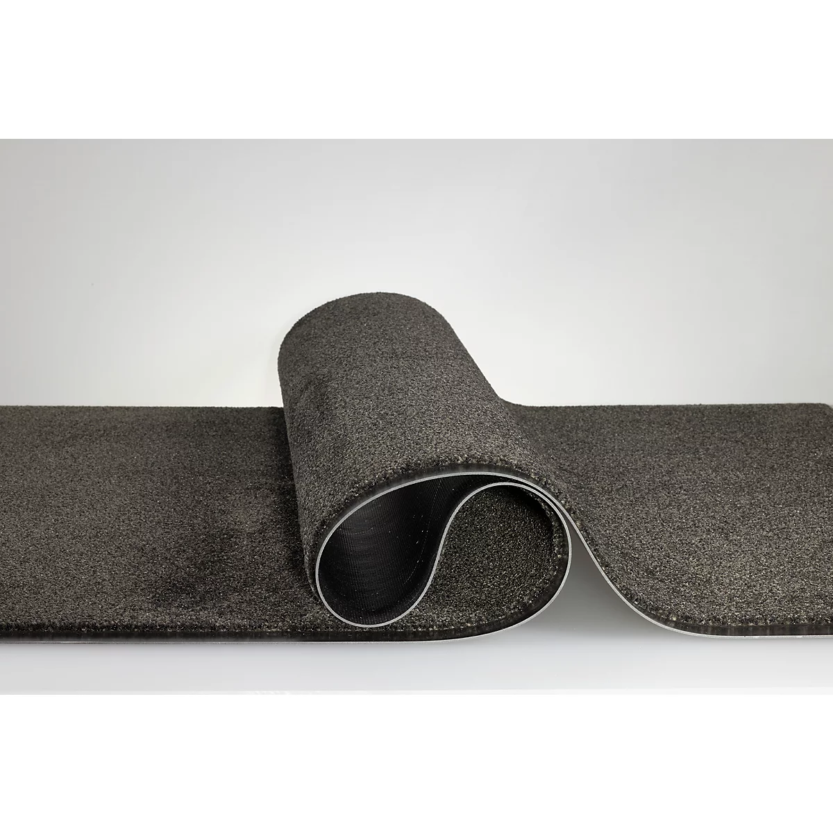 Un tapis de couloir gris enroulé sur un fond neutre.
