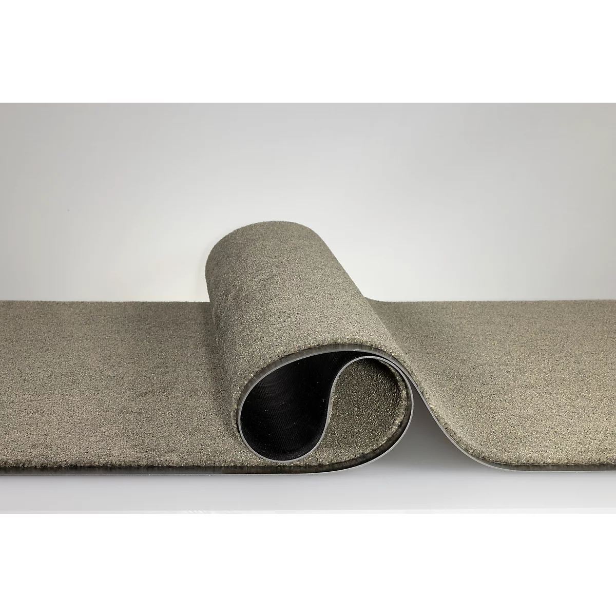 Une moquette beige-grise, enroulée sur une surface lisse.