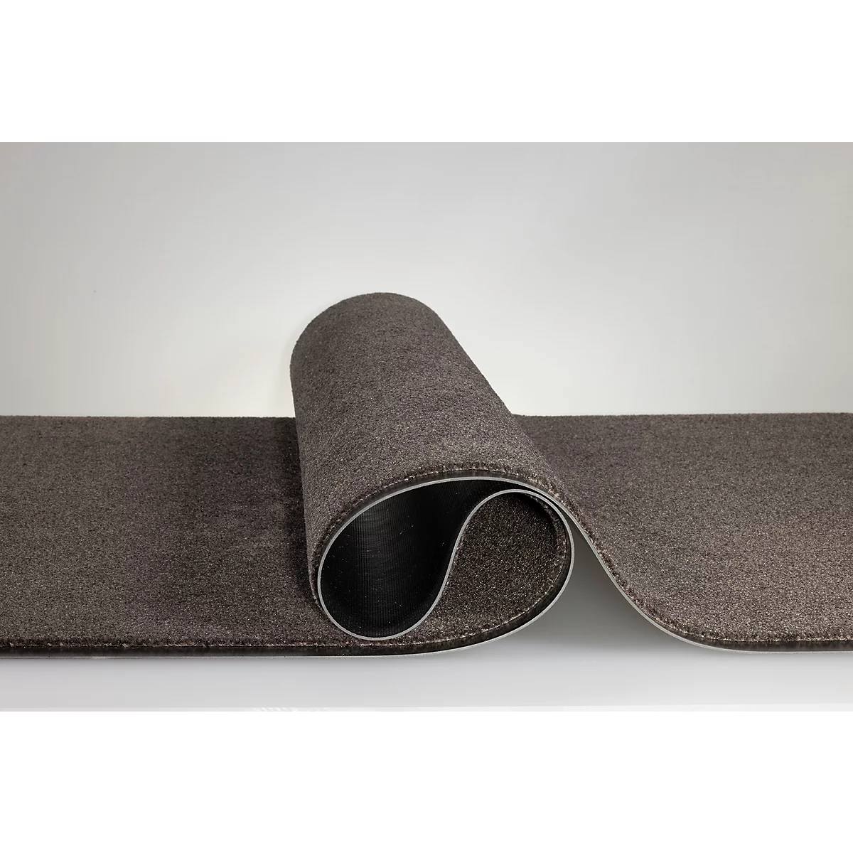 Un tapis de couloir brun foncé enroulé sur un fond clair.