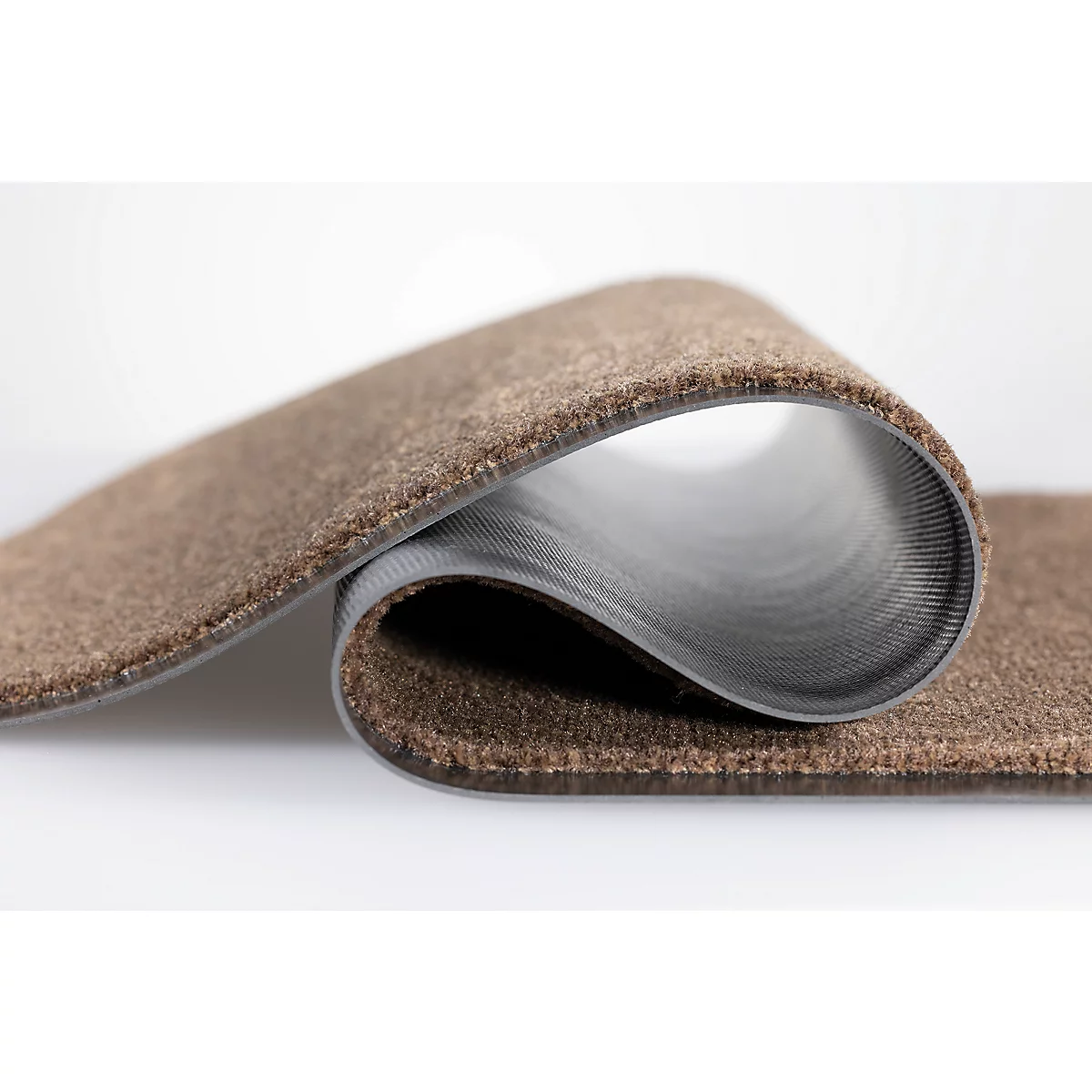 Un morceau de moquette marron courbé avec un envers gris et nervuré sur fond blanc.