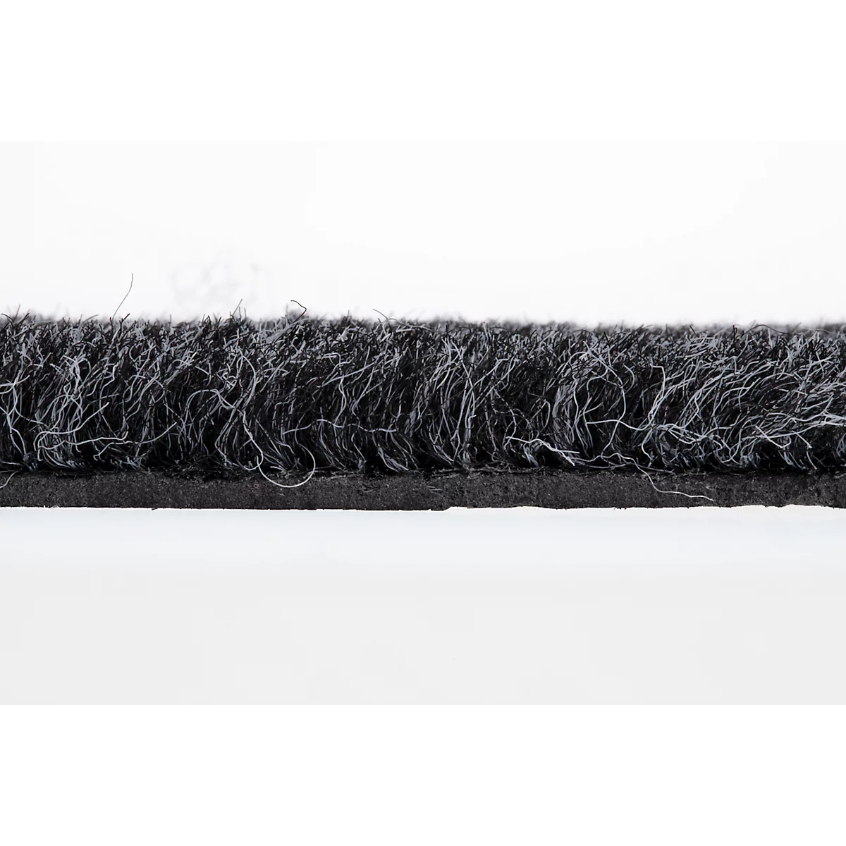 Gros plan d'un ruban d'étanchéité de porte noir avec de fines fibres gris clair sur fond clair.