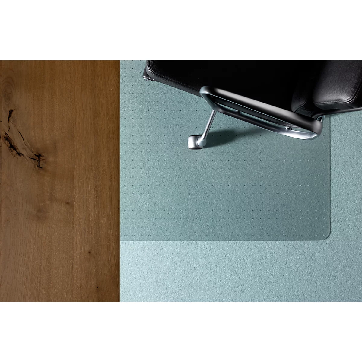 Vue de dessus : chaise de bureau sur un tapis de bureau turquoise et une surface en bois.