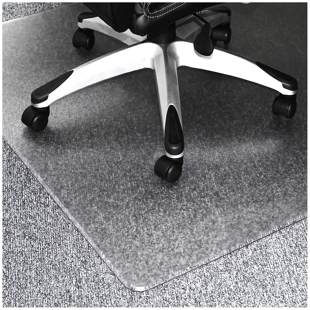 Tapis de protection transparent pour chaise de bureau sur moquette grise. Sous la chaise, qui est partiellement visible.